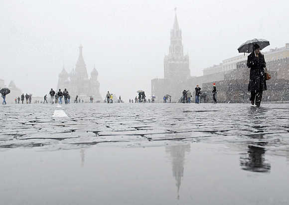 People walk across Red Square during snow in Moscow, Russia.