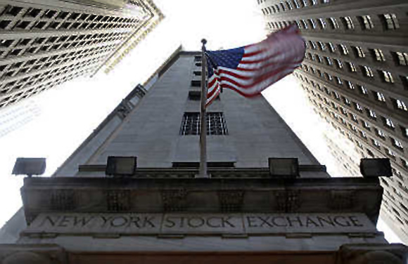 The US flag waves in the breeze above one of the entrances to the New York Stock Exchange.