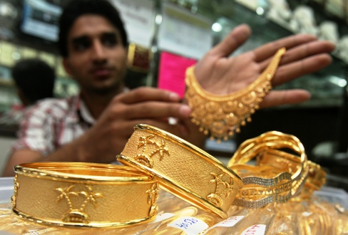 A salesman displays gold ornaments at a jewellery showroom in Chandigarh.