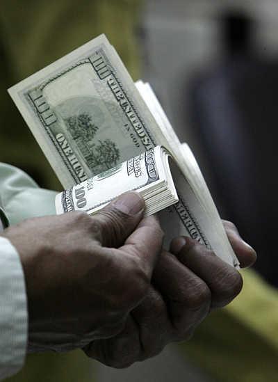 A customer counts dollar notes in Jakarta, Indonesia.