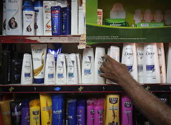 A salesman pickes up a bottle of shampoo in a shop. Photo is for representation purpose only.