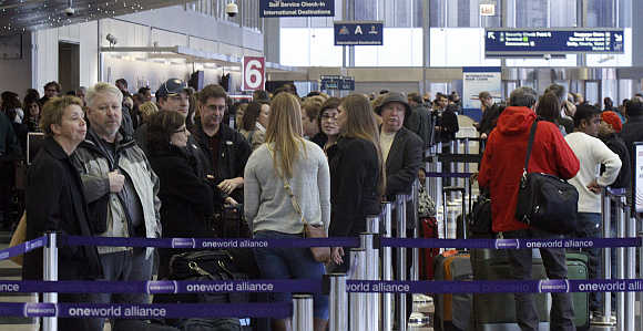 People wait in line at an American Airlines ticket counter at O'Hare International Airport in Chicago.