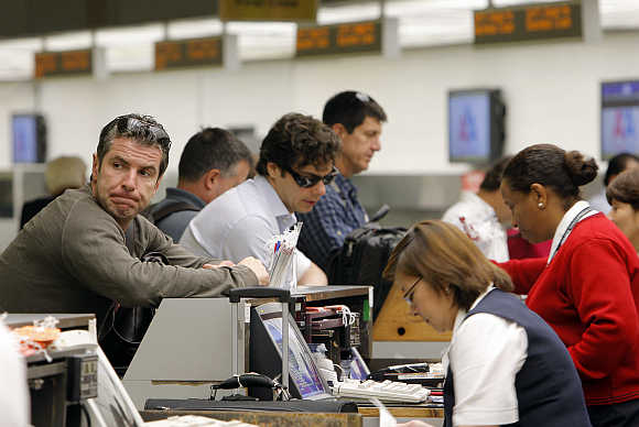 A man waits as he checks in at an American Airlines counter in Miami's International airport.