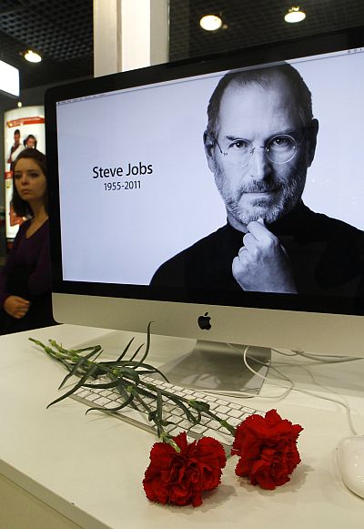 Carnations are placed before a computer screen showing a portrait of Apple co-founder and former CEO Steve Jobs at an Apple store in St. Petersburg.