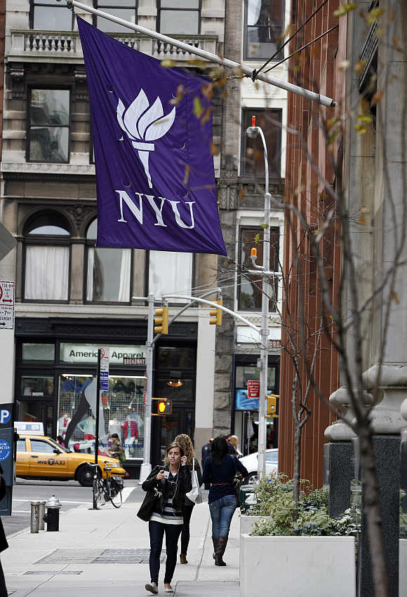 Students walk down the street at New York University in New York.
