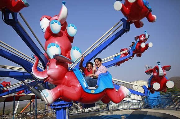Visitors gesture as they enjoy a ride at the 'Adlabs Imagica' theme park in Khopoli, about 75km from Mumbai.