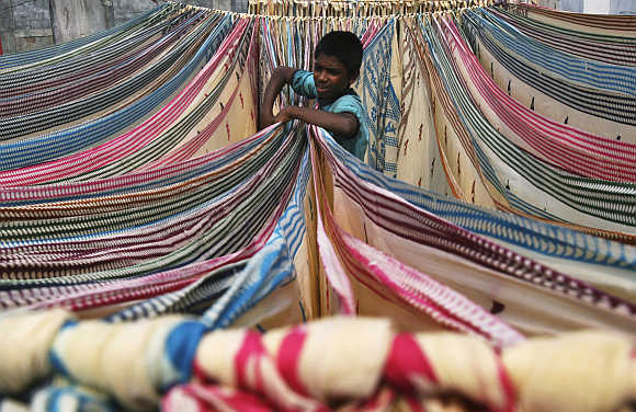 A boy separates starched sarees on the roof of a cotton factory in Hyderabad.