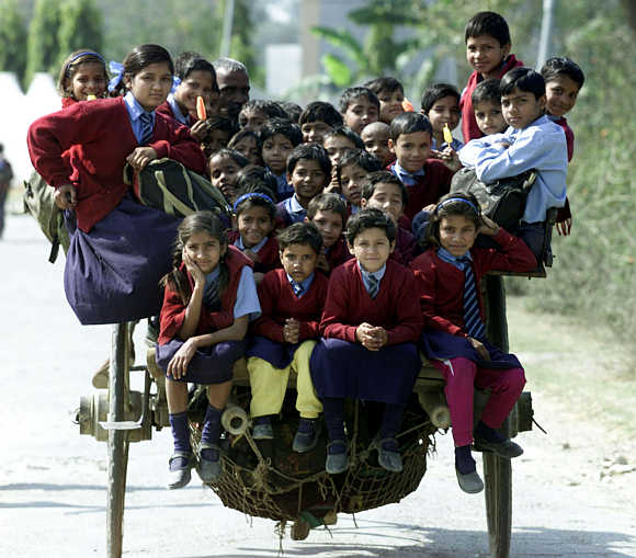 Children ride in a cart on the way home from school on the outskirts of New Delhi.