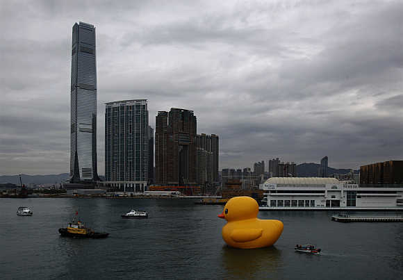 Rubber Duck by Dutch conceptual artist Florentijn Hofman floats at Hong Kong's Victoria Harbour, with the International Commerce Centre in the background.