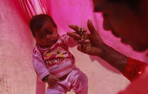 Gopal Kishan, 16, plays with his four-month-old baby, Alok, near Baran in Rajasthan.