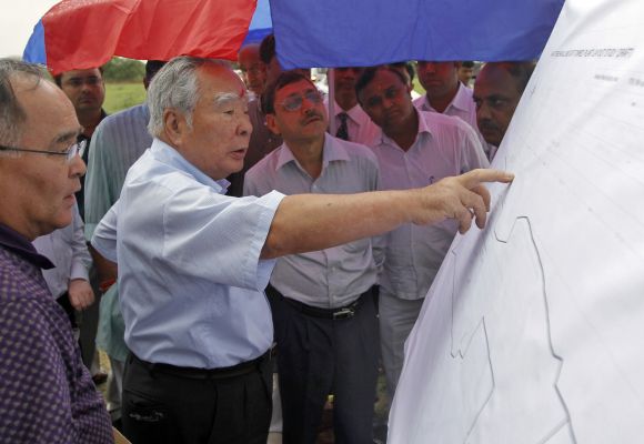 Suzuki Chairman and CEO Osamu Suzuki, wearing a traditional tikka or a red mark on his forehead, checks the site map during his visit to the site of the proposed Maruti Suzuki plant at Hansalpur village in the western Indian state of Gujarat.