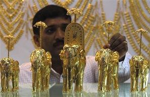 An employee displays gold models of elephants at the "Gem and Jewellery India International Exhibition 2013" (GJIIE) in Chennai. Photograph: Babu/Reuters