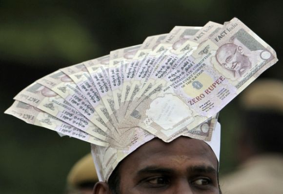 A supporter of veteran Indian social activist Anna Hazare wears a cap lined with fake currency notes while attending a public meeting by Hazare.