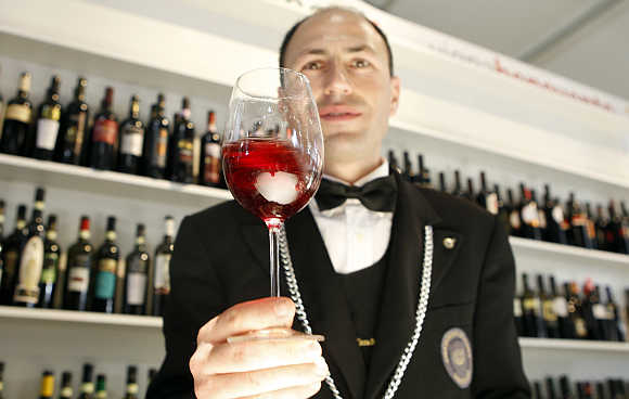 A sommelier tests a glass of red wine during the Vinitaly wine expo in Verona, Italy.