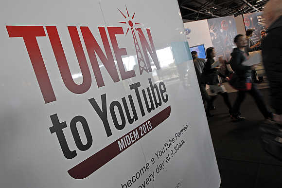 Visitors walk past a YouTube stand during the International Record Music Publishing and Video Music Market in Cannes, France.