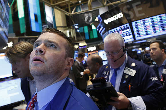 Specialist trader Frank Massiello watches his screen on the floor at the New York Stock Exchange.