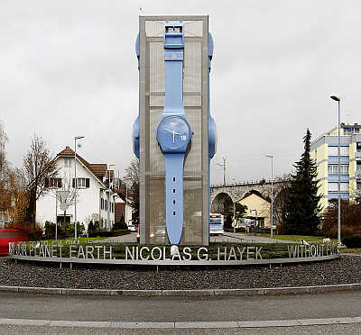 Cars drive past a giant Swatch watch placed in the centre of a roundabout in Grenchen, Switzerland.