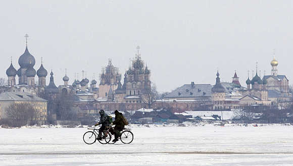 Men ride bicycles on ice of a lake in front of the cathedrals of the Kremlin in Rostov Veliky, about 200km from Moscow.