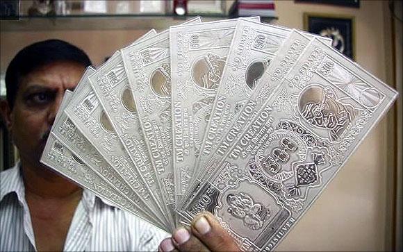  jeweller displays silver plates in the form of Indian rupee notes in Chandigarh.