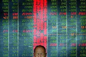 An investor reacts in front of an electronic board showing stock information at a brokerage house in Taiyuan, Shanxi province