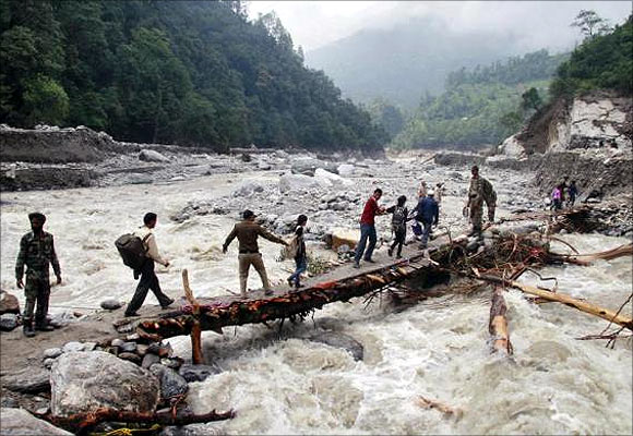 Indian army personnel help stranded people cross a flooded river after heavy rains in the Himalayan state of Uttarakhand.