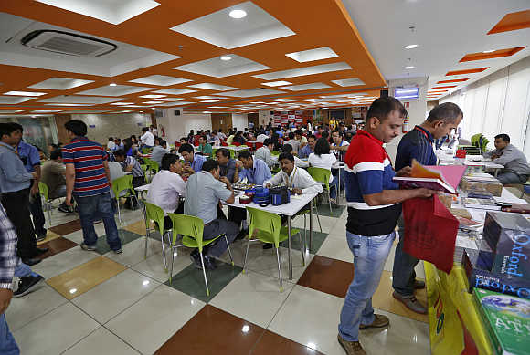 Employee take their lunch at a cafeteria inside Tech Mahindra office building in Noida.