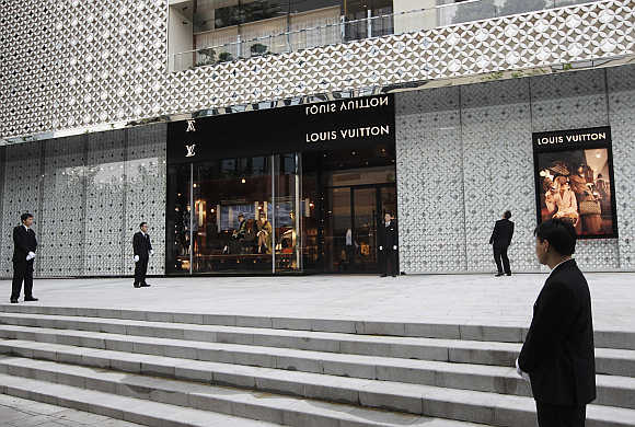Security guards stand in front of the largest Louis Vuitton store in China in Shanghai.