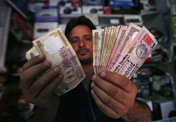 A shopkeeper counts rupee notes in Jammu.