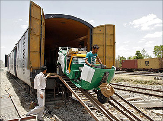 A new auto rickshaw is unloaded from a goods train at a storage facility at Sanand.