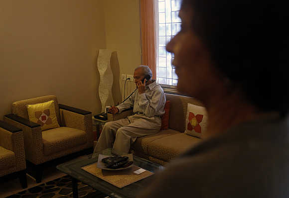 Aruna Gokhale, 81, watches as her husband Vidyadhar Gokhale, 84, speaks on the phone in their flat at the Athashri retirement village in Baner, on the outskirts Pune.