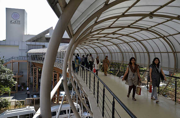 Employees cross an overpass at the headquarters of iGate in Bangalore.