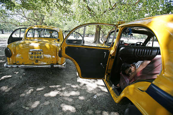 A driver sleeps inside his parked Ambassador car in Kolkata.
