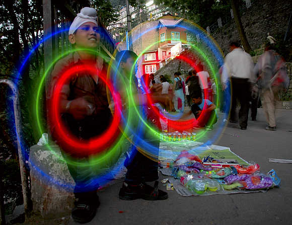 A roadside vendor spins light sticks to attract customers in Shimla.