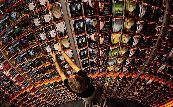 Andrea Bauer of the German publishing house Droemer-Knaur makes final adjustments on a large bookshelf to present the latest publications at the book fair in Frankfurt, Germany.