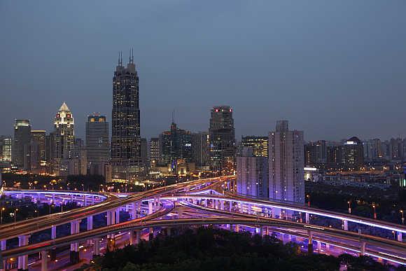 An aerial view shows vehicles travelling on intersections at night in downtown Shanghai, China.