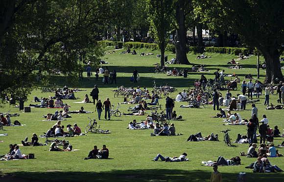 People enjoy the sunny weather in a park in Heidelberg, 90km south of Frankfurt, Germany.