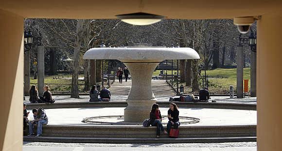 People enjoy the sun at a fountain in front of the opera house in Frankfurt, Germany.