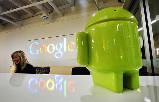 A Google Android figurine sits on the welcome desk as employee Tracy McNeilly smiles at the new Google office in Toronto.