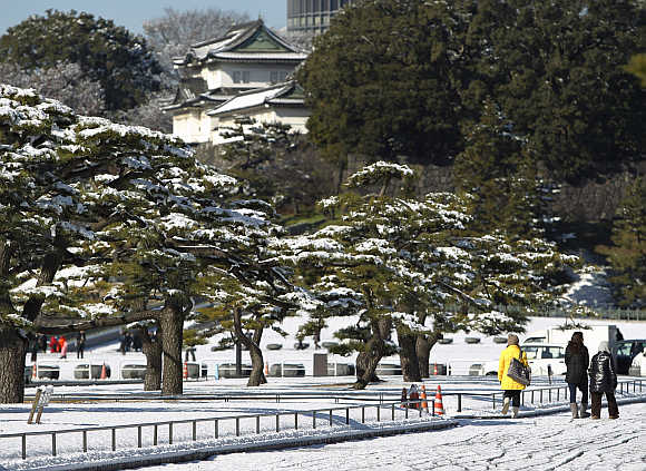 People walk near the Imperial Palace covered with snow in Tokyo, Japan.