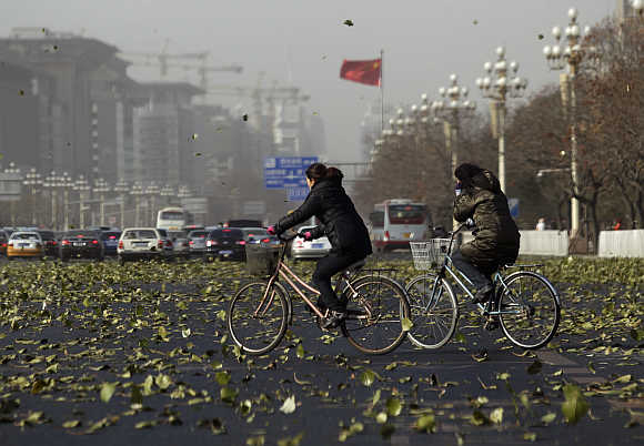 Cyclists cross Chang'an Avenue amid strong winds in central Beijing, China.