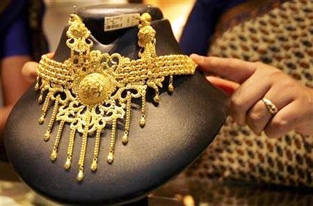 Reuters/Reuters - A saleswoman displays a gold necklace at a jewellery shop in Agartala.