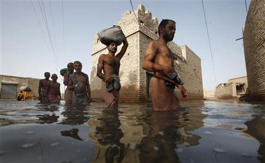 Villagers displaced by flooding wade through floodwaters.