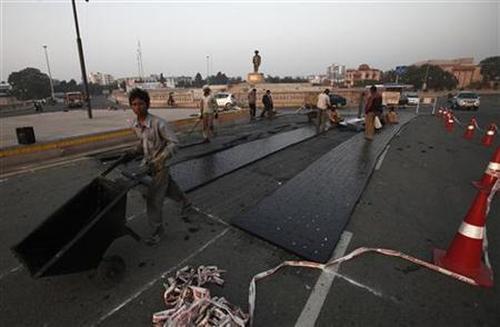Labourers work at a road construction site outside Ambedkar memorial park in Lucknow.