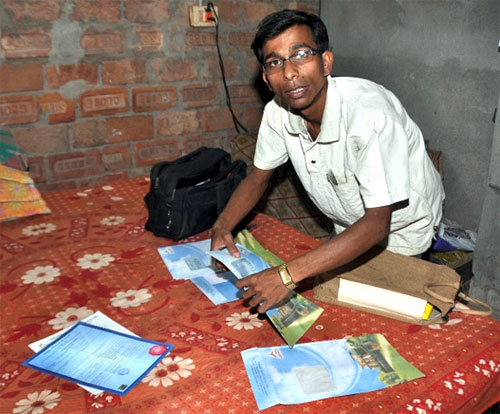 Siddhartha Das, a Saradha agent, goes through his investment papers at his make-shift home.