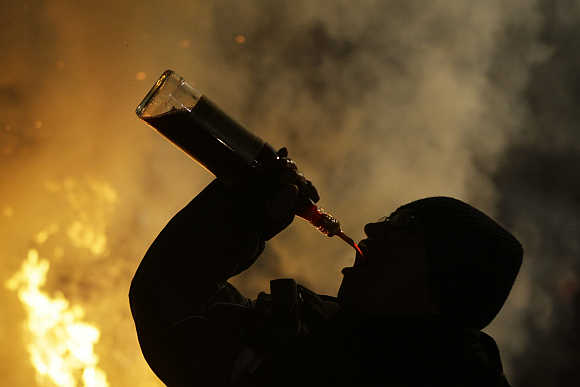 A man downs alcohol during the annual Saint Anthony purification ceremony in the village of San Bartolome de los Pinares near Avila in Spain.
