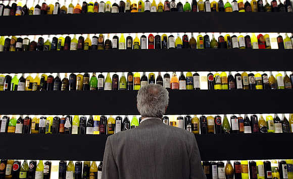 A man looks at bottles of wine on display at the Vinitaly wine expo in Verona, Italy.