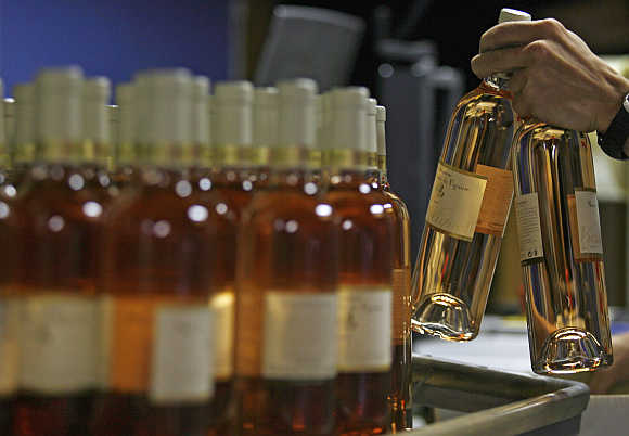 A worker prepares bottles of rose wine at the Domaine Saint Andre de Figuiere at La Londe Les Maures in Provence, France.