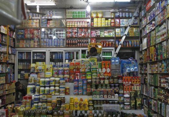 A salesman carries items in a basket inside a family-run grocery store in New Delhi.