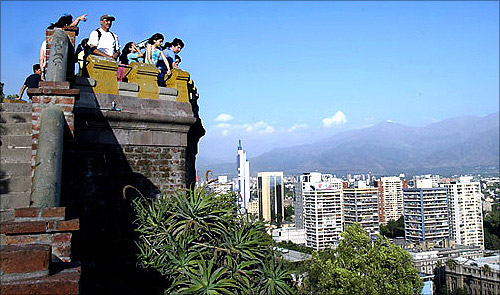 Tourists take in the view of the Andes Mountains from Santa Lucia Hill in downtown Santiago.