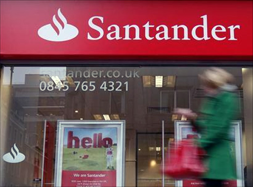A pedestrian walks past a branch of a Santander bank in London.